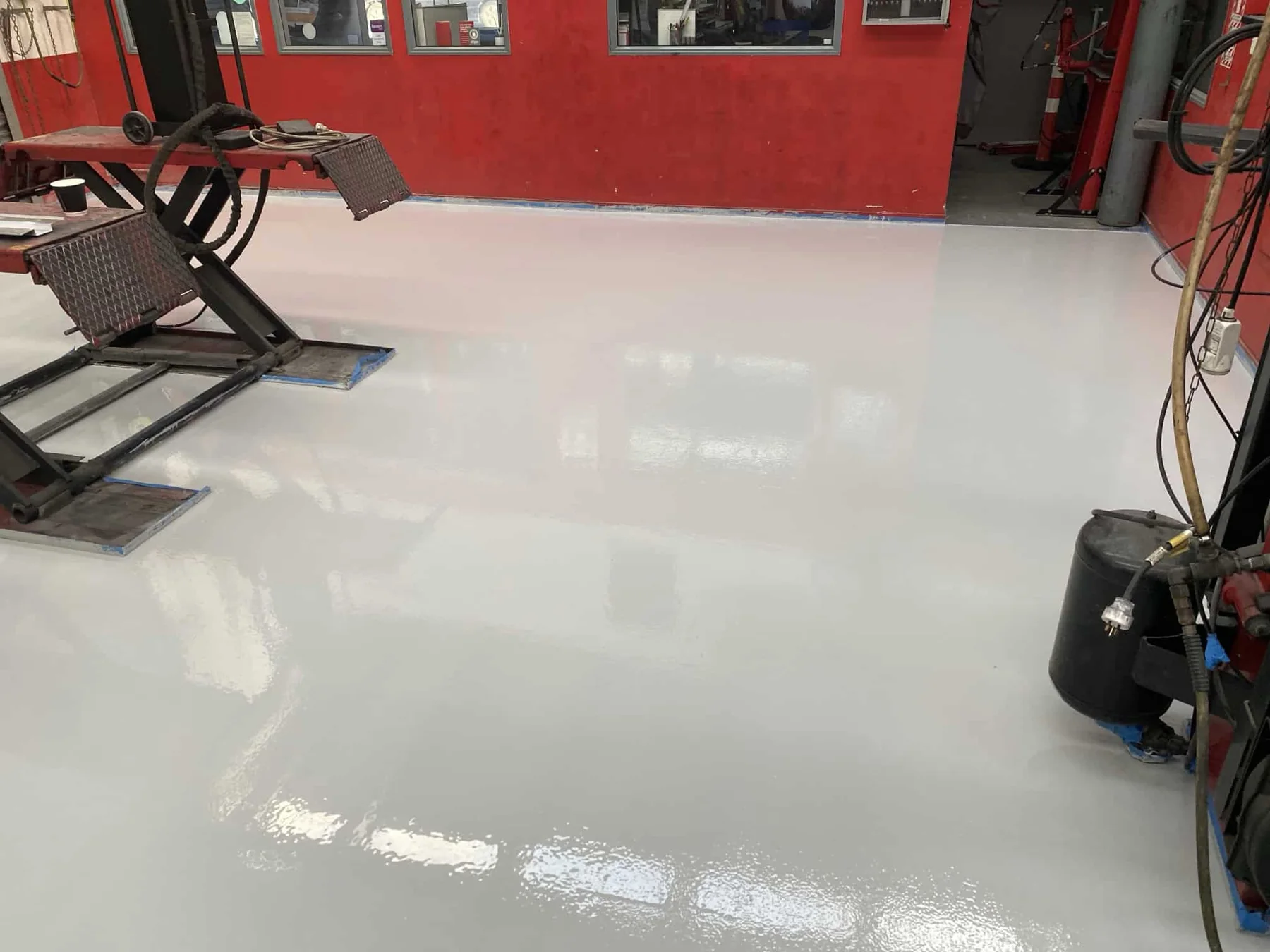 Fresh glossy light-grey painted concrete workshop floor