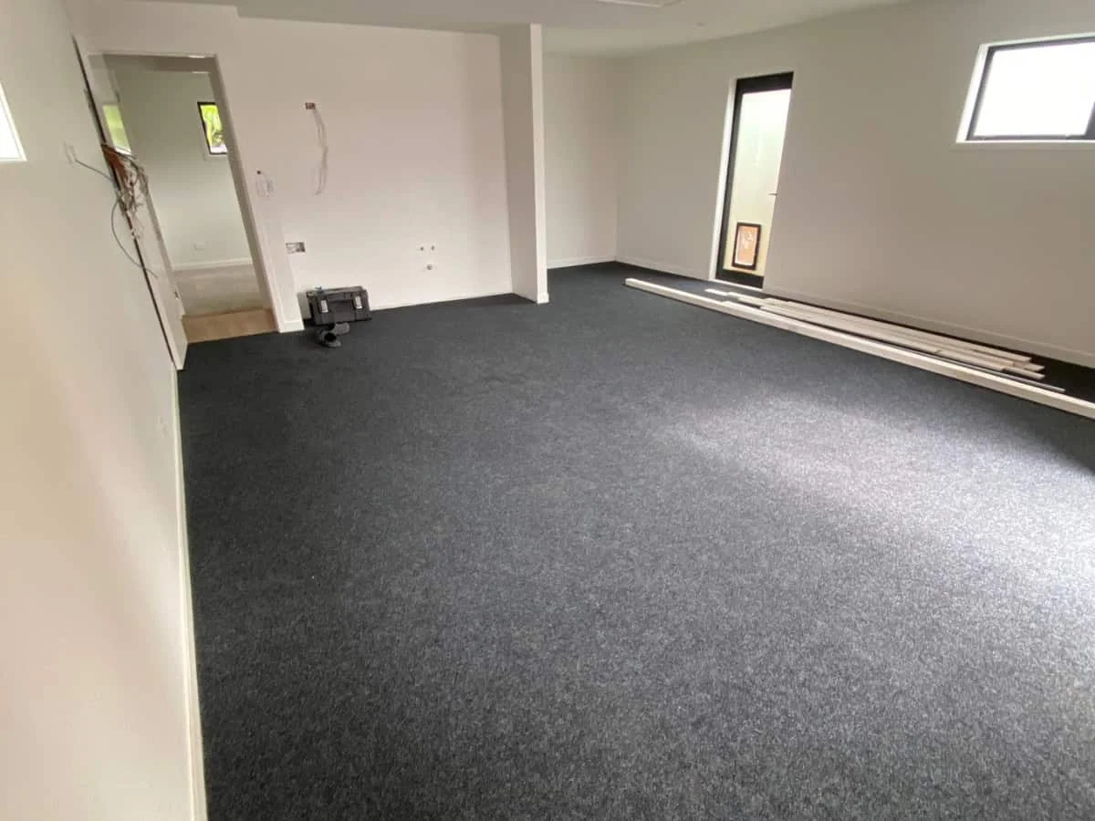 FlooringPro installer fitting residential carpet in an Auckland home