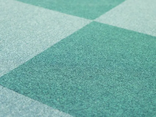 Green commercial carpet tiles laid in a geometric pattern